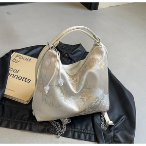 Detail of satin shoulder bag with traditional Chinese floral embroidery and pearl accents
