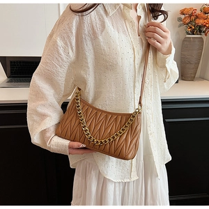 Vue détaillée du sac plissé marron caramel avec chaîne dorée décorative et bandoulière cuir