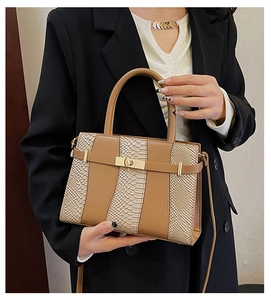 Detail of snake pattern Kelly bag featuring brown leather patchwork and metal clasp
