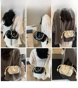 Detailed views of pleated drawstring bucket bag with bead chain and butterfly accent