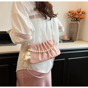 Pink pleated cloud bag with pearl strap, white ribbon bow, and chain shoulder strap