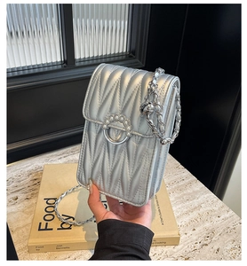 Dettaglio borsa trapuntata argento con catena e chiusura con anello di perle