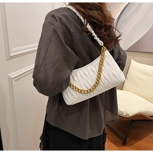 Détail du sac plissé blanc avec chaîne dorée et bandoulière froncée sur mannequin