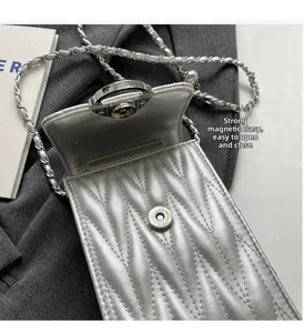 Dettaglio della borsa argento trapuntata con chiusura magnetica e tracolla a catena