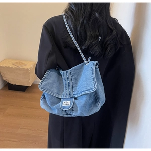 Detailed back view of a blue denim shoulder bag with silver chain and metal turn-lock