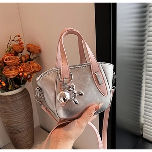 Détail du mini sac argenté avec poignées roses et breloque chien ballon argentée