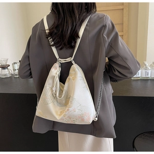 Detail view of jacquard floral backpack with adjustable straps and metal chain link