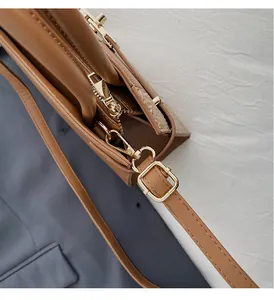 Detail of golden hardware adjustment buckle on brown snakeskin pattern Kelly handbag