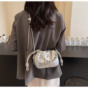 Detail of silver crocodile pattern crossbody bag with bead chain and butterfly charm
