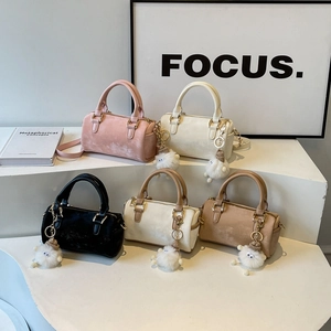 Classic Boston bags in five colors with cute pompom charms on a white display stand