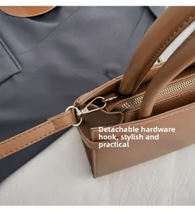 Close-up of golden hardware D-ring and lobster clasp on brown snakeskin Kelly bag