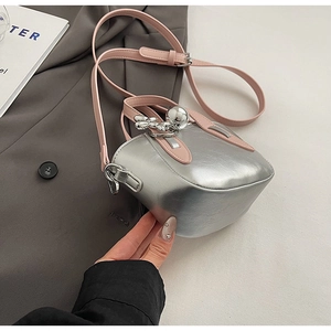 Détail du sac seau métallisé argenté avec bandoulière rose et breloque en forme de boule