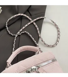 Detail of pink quilted leather mini bag with chain strap and top handle design