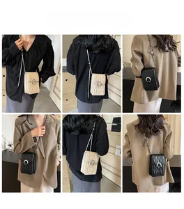 Dettaglio mini borse a tracolla trapuntate a V in beige e nero con fibbia di perle