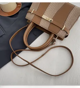 Detailed view of brown tote bag with contrast textures and golden square buckle lock