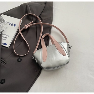 Détail de la poignée en oreilles de lapin et de la texture bicolore d'un petit sac