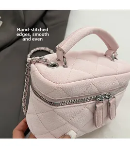 Detailed view of pink quilted mini bag with silver chain strap and smooth stitched edges