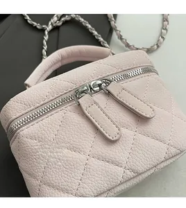 Detail of pink quilted leather texture and smooth silver dual metal zippers on vanity bag