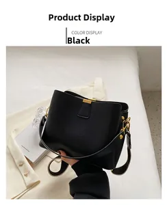Close-up of black textured bucket bag with gold hardware and wide woven strap