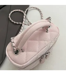 Detail of pink quilted leather mini bag featuring silver chain and durable top handle