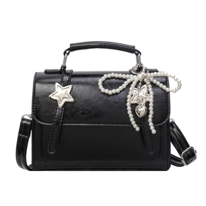 Sac bandoulière noir brillant avec breloque nœud en perles et détail étoile argentée