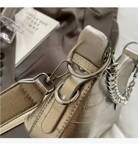 Close-up of silver crocodile texture bag with chunky metal chain and buckle detail