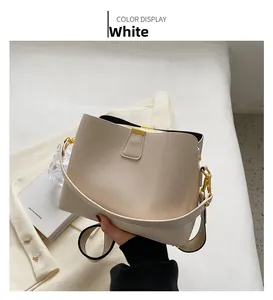 Detail of white bucket bag with lychee pattern leather and gold metal hardware