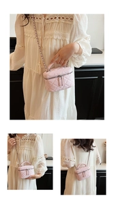 Pink quilted crossbody bag with chain strap and top handle shown on model in studio