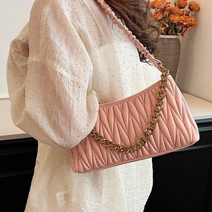 Sac hobo plissé rose avec chaîne dorée et bandoulière nuage porté par un mannequin