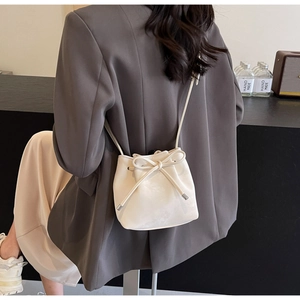 Vue arrière d'un mannequin portant un sac seau blanc avec cordon de serrage et détail de nœud