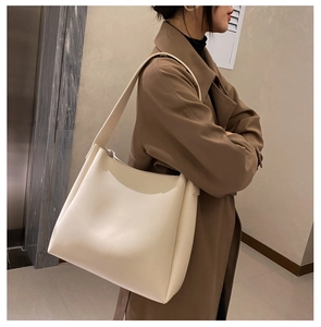 Detailed view of the large capacity cream tote bag on shoulder for daily office commuting