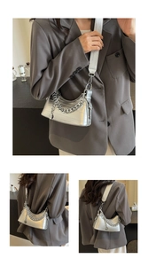 Detail of silver crocodile pattern bag with metallic chain strap and minimalist design