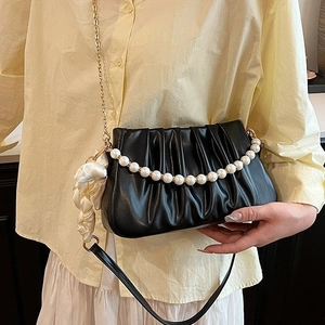 Elegant black pleated shoulder bag with pearl handle and silk ribbon accessory