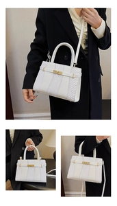 Detail of white snakeskin texture patchwork on a Kelly bag with golden turn-lock closure