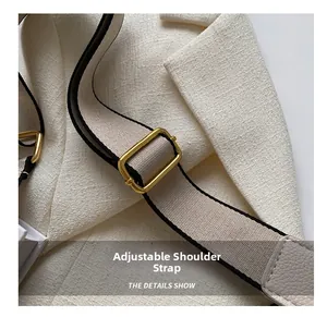 Detail showing adjustable canvas strap with gold metal buckle and pebble leather link