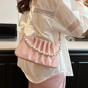 Pink pleated shoulder bag with pearl chain and silk scarf strap shown on model