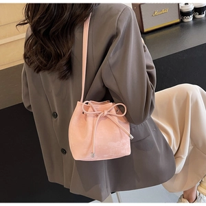Détail du sac seau en cuir mat rose avec nœud à cordon et fine bandoulière réglable