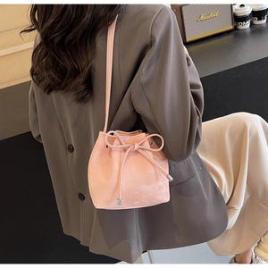 Gros plan détaillé du sac seau rose avec cordon, nœud décoratif et bandoulière fine