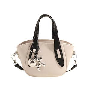 Sac bandoulière beige chic avec poignées noires et breloque chien ballon argenté