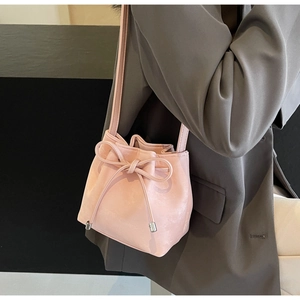 Détail du sac seau en similicuir rose avec cordon de serrage et embouts métalliques argentés