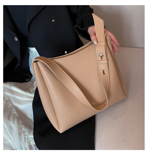 Close-up of khaki leather tote bag with soft pebbled texture and wide shoulder strap