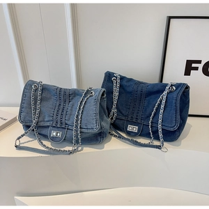 Detail of blue denim flap bags featuring silver metal swivel locks and chain straps