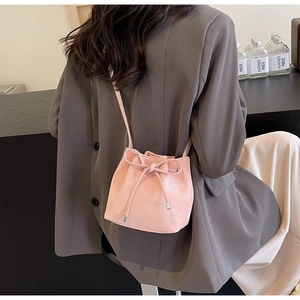 Détail du sac seau rose avec cordon de serrage, nœud élégant et embouts en métal argenté