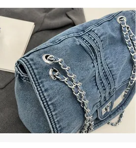 Gros plan sur la texture du denim délavé avec chaîne argentée et détails d'œillets