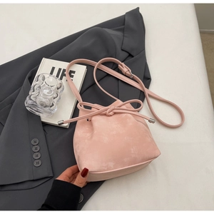 Détail du sac seau rose à cordon avec finition mate et bandoulière réglable