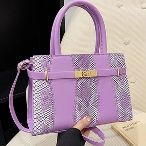Snake skin pattern purple Kelly bag with dual textures and golden hardware on books