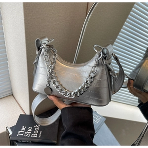 Close-up of silver crocodile pattern crescent bag with metallic chain and mirror effect