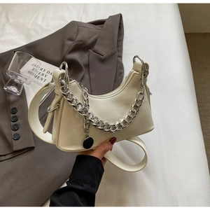 Detail of white embossed leather handbag with silver chain and chic crescent shape