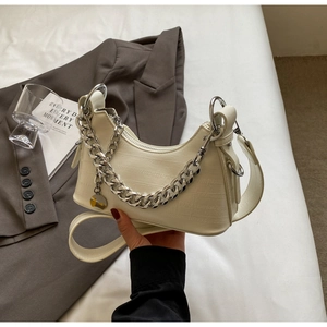 Detail of crescent shoulder bag featuring crocodile pattern leather and silver chain