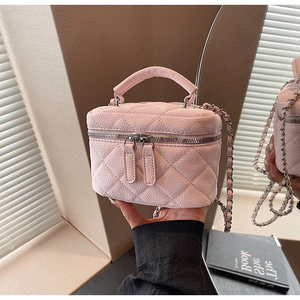 Detail of light pink quilted leather mini bag with silver chain and dual zippers